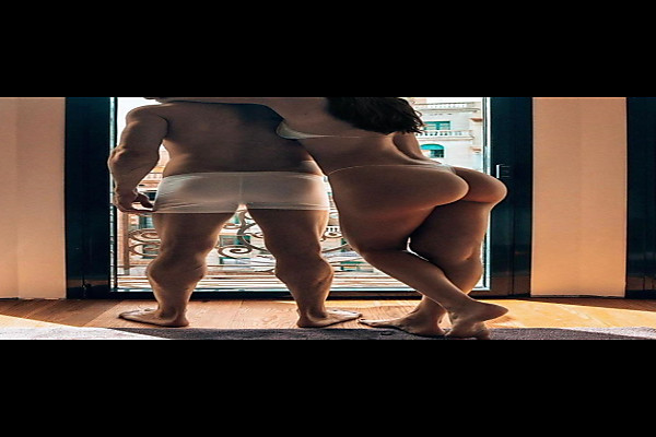 Young Couple Looking Out of The Window in Undies